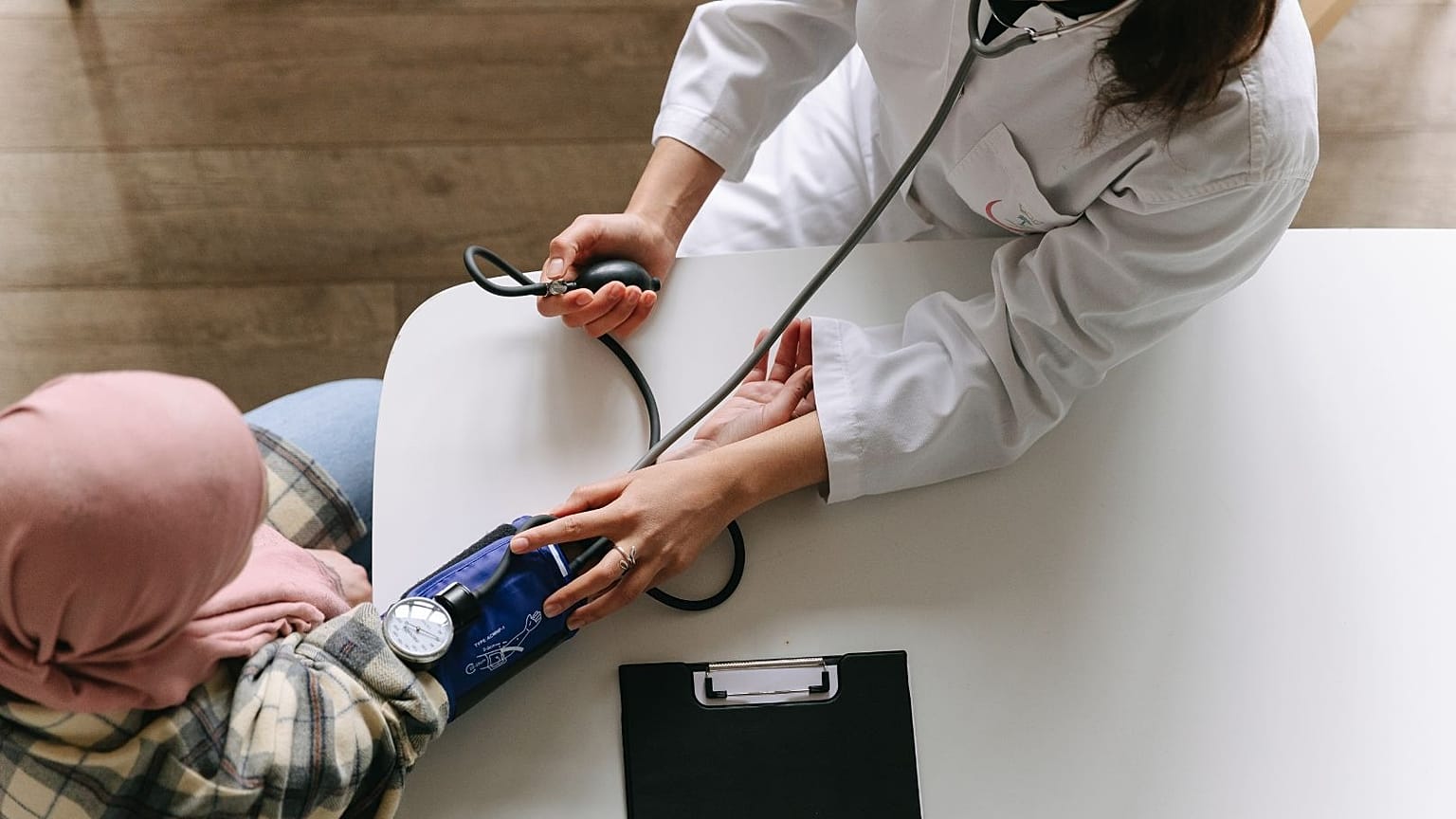 Ein Arzt misst den Blutdruck eines Patienten.