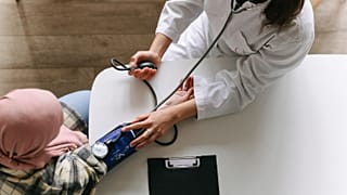Un médecin mesure la tension artérielle d'un patient.