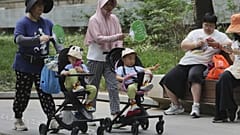 Nők tolják a babakocsiljaikat Pekingben