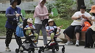 Nők tolják a babakocsiljaikat Pekingben