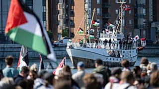 Dimostranti con bandiere palestinesi osservano l'arrivo della nave Hanzala, diretta a Gaza, nel porto di Malmö, Svezia, 8 maggio 2024