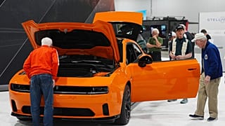 FILE - Shoppers look over a 2025 Dodge Charger Daytona hardtop in the Stellantis display at the Colorado Auto Show on 17 April 2025, in Denver.