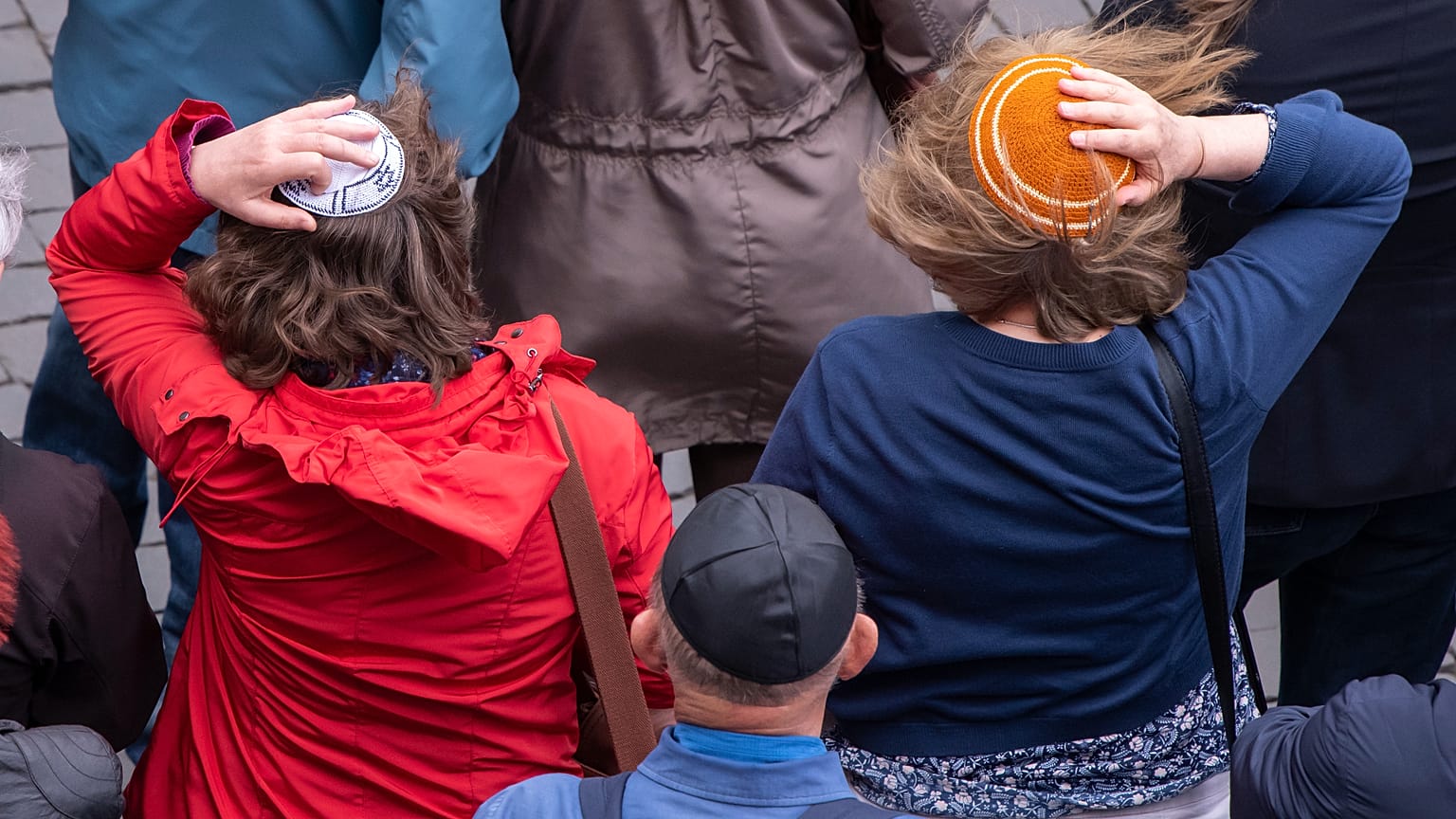 Donne tengono stretta la loro kippah contro il forte vento durante una manifestazione contro l'antisemitismo a Erfurt, in Germania, 25 aprile 2018