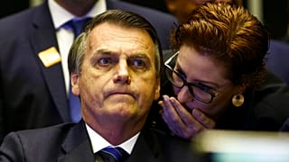 O então presidente do Brasil, Jair Bolsonaro, ouve Carla Zambelli sussurrar ao seu ouvido durante uma reunião do Congresso, em Brasília, Brasil, 29 de maio de 2019