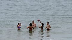 Παραθεριστές παίζουν με μια μπάλα στο νερό στην παραλία Carcavelos, στα περίχωρα της Λισαβόνας