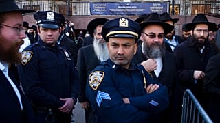 ضباط شرطة مدينة نيويورك يراقبون تجمع الحاخامات لالتقاط صورة جماعية في المقر العالمي لحركة حاباد-لوبافيتش، الأحد 4 نوفمبر/تشرين الثاني 2018، في نيويورك.