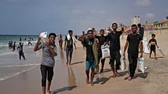 فلسطينيون يجمعون المساعدات التي هبطت في البحر الأبيض المتوسط بعد إسقاطها جواً فوق وسط غزة، على شاطئ الزوايدة، قطاع غزة، الثلاثاء 29 يوليو/تموز 2025.