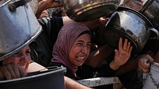 Παλαιστίνιοι παλεύουν για τρόφιμα που τους δόθηκαν σε μια κοινοτική κουζίνα στην πόλη της Γάζας, 26 Ιουλίου 2025.