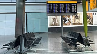 Empty seats and a board showing cancelled flights at Heathrow Terminal 5, 21 March, 2025