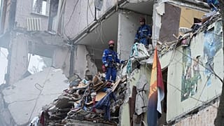 Rescuers work in a destroyed apartment building after a Russian missile attack in Kyiv, 31 July 2025