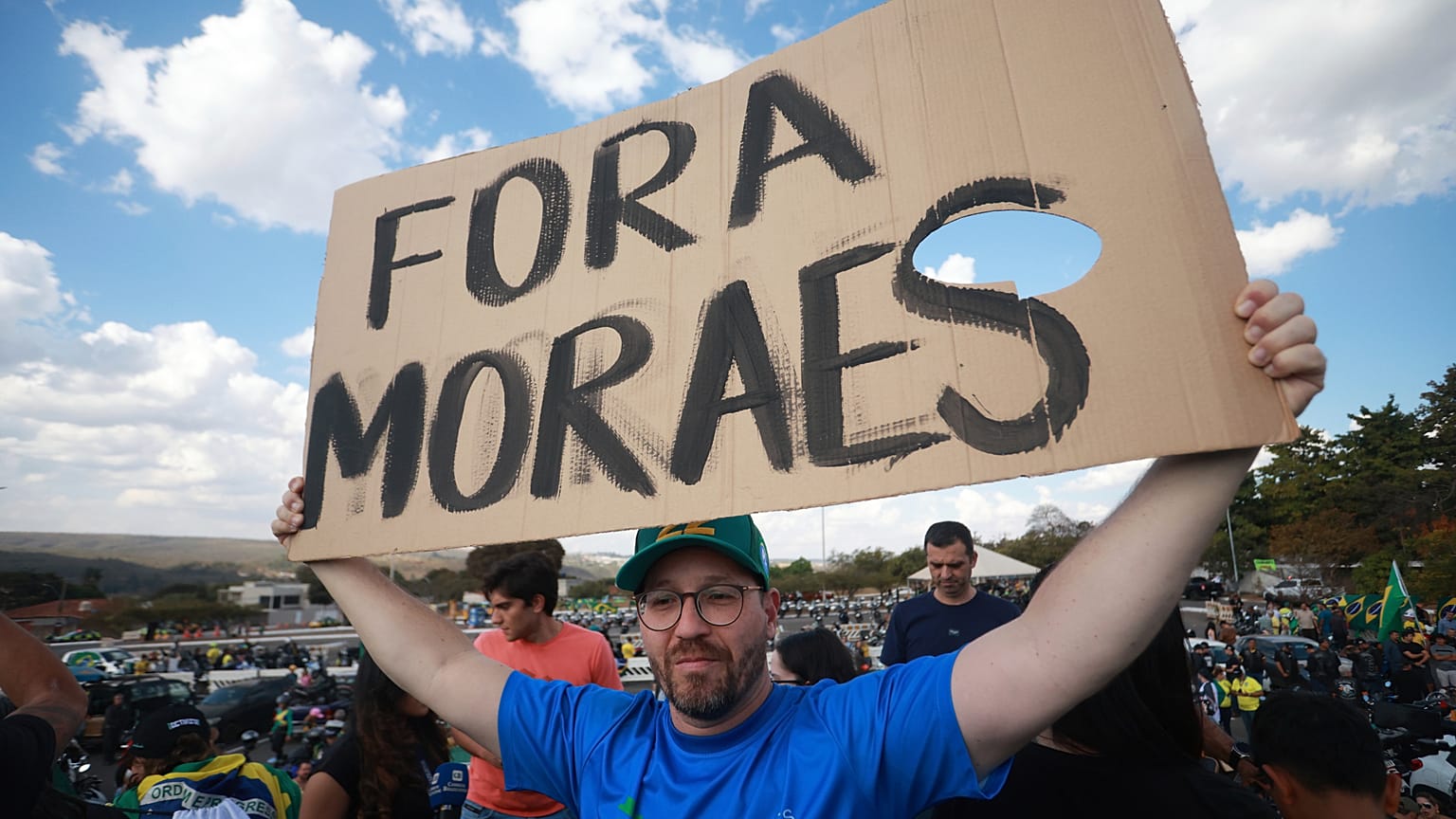 A supporter of Brazil's former President Jair Bolsonaro holds a sign "Moraes get out" in during a protest over Bolsonaro's Supreme Court trial in Brasília, 29 July 2025