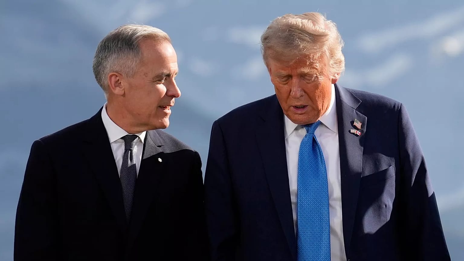 O primeiro-ministro do Canadá, Mark Carney, conversa com o Presidente Donald Trump antes de uma fotografia de grupo na Cimeira do G7, no Canadá, a 16 de junho de 2025.