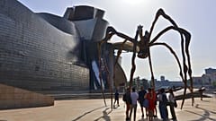 Turistas se reúnen bajo la escultura Maman de Louise Bourgeois en el exterior del Museo Guggenheim durante una ola de calor, 30 de junio de 2025.