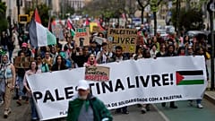 Διαδηλωτές κρατούν πανό με την επιγραφή "Free Palestine" κατά τη διάρκεια διαμαρτυρίας με αίτημα την κατάπαυση του πυρός στη Γάζα και τη στήριξη των Παλαιστινίων, στη Λισαβόνα