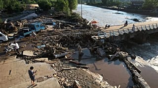 Tianjin’in Jizhou bölgesinde ani selin ardından insanlar hasar gören nehir kıyısından geçiyor, 29 Temmuz 2025.