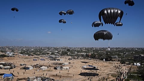 Palestinians rush to collect humanitarian aid airdropped into Zawaida in the central Gaza Strip, Thursday, July 31, 2025.