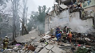 Equipas de salvamento trabalham num edifício de apartamentos destruído após um ataque de mísseis russos em Kiev, 31 de julho de 2025