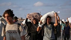 يحمل فلسطينيون أكياس دقيق أُنزلت من قافلة مساعدات إنسانية متجهة إلى مدينة غزة من شمال قطاع غزة، يوم الخميس 31 يوليو/تموز 2025. 