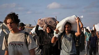 يحمل فلسطينيون أكياس دقيق أُنزلت من قافلة مساعدات إنسانية متجهة إلى مدينة غزة من شمال قطاع غزة، يوم الخميس 31 يوليو/تموز 2025. 