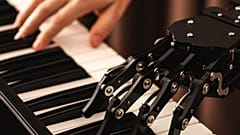 Ein Mensch und ein Roboter spielen Klavier.
