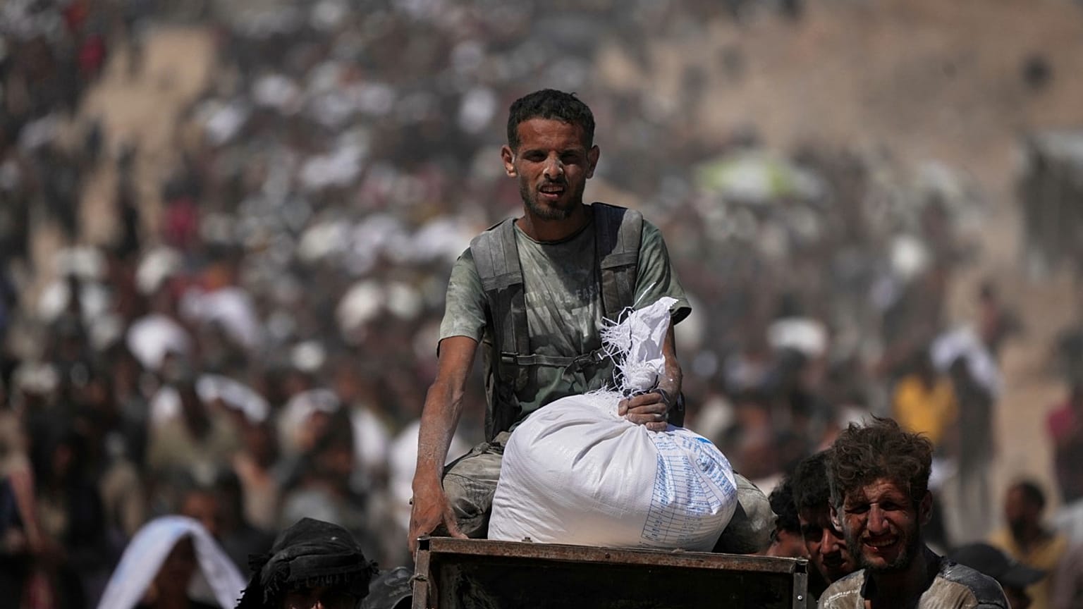 فلسطينيون يحملون أكياس الدقيق، شمال قطاع غزة، الجمعة 1 أغسطس/آب 2025. 