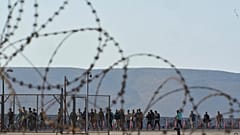 Μετανάστες που διασώθηκαν νότια της Κρήτης περπατούν μετά την άφιξή τους στο λιμάνι του Λαυρίου, 10 Ιουλίου 2025