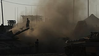 جنود إسرائيليون يعملون على دباباتهم في نقطة تجمع قرب قطاع غزة، جنوبي إسرائيل، في 21 يوليو/تموز 2025.