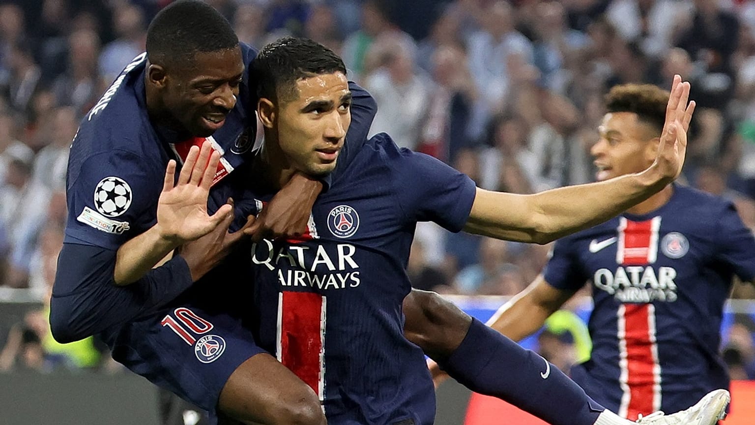 Achraf Hakimi a nyakán lógó csapattársával, Ousmane Dembelével ünnepel, miután gólt lőtt a PSG - Internazionale (5-0) BL-döntőben Münchenben 2025. május 31-én