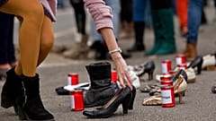 Frauenschuhe und Kerzen mit den Namen von Opfern von Gewalt gegen Frauen stehen während einer Demonstration vor dem Rathaus in Bukarest, Rumänien, Dienstag, 25. November 2014