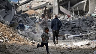 طفل يركض بجانب مبانٍ سكنية مدمرة تضررت نتيجة الهجوم الجوي والبرّي الإسرائيلي في البريج، وسط قطاع غزة، يوم الأربعاء 22 يناير 2025