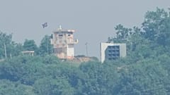  Um posto de guarda militar norte-coreano, à esquerda, e um altifalante são vistos de Paju, Coreia do Sul, perto da fronteira com a Coreia do Norte, a 12 de junho de 2025.