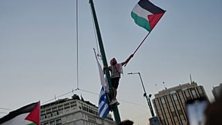 متظاهر يلوح بعلم فلسطيني خلال مظاهرة ضد الحرب في قطاع غزة، خارج البرلمان اليوناني في وسط أثينا، الخميس 24 يوليو/تموز 2025. 