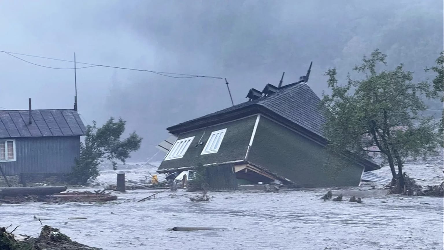 Nesta imagem divulgada pelos serviços de emergência romenos de Suceava (ISU Suceava), uma casa é danificada após uma inundação repentina na aldeia de Brosteni, no norte da Roménia