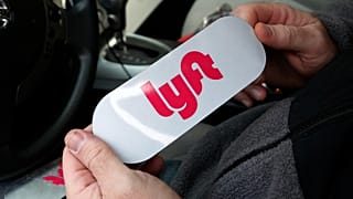 In questa foto del 31 gennaio 2018, un autista di Lyft tiene in mano un logo Lyft prima di installarlo sulla sua auto a Pittsburgh.