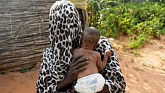 امرأة فرت من الحرب في السودان تحمل طفلها في مخيم للاجئين في أدري، تشاد، 5 أكتوبر 2024.