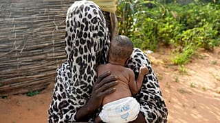امرأة فرت من الحرب في السودان تحمل طفلها في مخيم للاجئين في أدري، تشاد، 5 أكتوبر 2024.