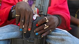 Bir çete üyesi, Port-au-Prince'de Ölüler Günü'nün kutlandığı geleneksel Fete Gede festivali sırasında silahıyla poz verirken, 1 Kasım 2024