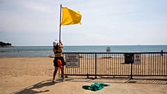 Ένας ναυαγοσώστης υψώνει την κίτρινη σημαία σε παραλία των Ηνωμένων Πολιτειών.