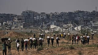 Imagen de palestinos llevando sacos con alimento en Gaza.
