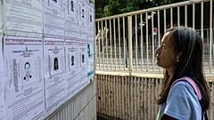 Bir kadın 16 aktivistin fotoğrafının yer aldığı broşürü incelerken, 4 Ağustos 2025