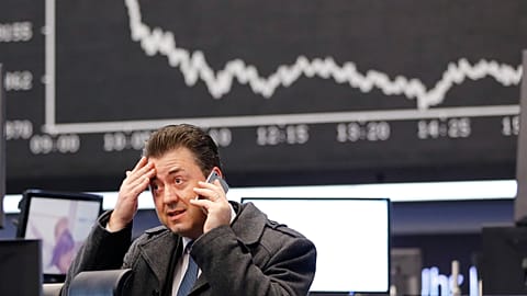 A trader makes a phone call when the German stock index DAX fell.