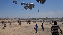 Palästinenser eilen, um die per Fallschirm abgeworfene humanitäre Hilfe in Zawaida im zentralen Gazastreifen zu sammeln, Montag, 4. August 2025.