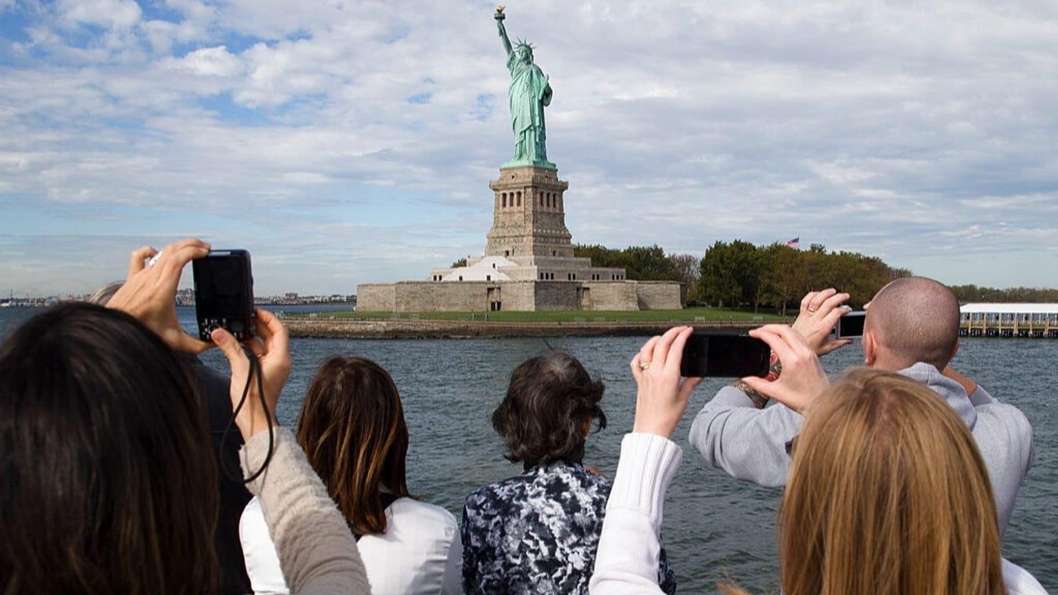 Pasajeros fotografían la Estatua de la Libertad en un barco turístico en el puerto de Nueva York, el sábado 12 de octubre de 2013.