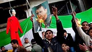 أشخاص يحرقون صورا للرئيس السوري السابق بشار الأسد خلال مظاهرة ضد نظامه في ضواحي إدلب ، شمال سوريا ، الأحد فبراير. 26, 2012.
