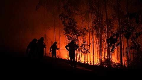 FILE. Firefighters work as a fire progresses in the Fuente de Faro de Brantuas area in Ponteceso, northwest Spain. 3 Aug. 2025.