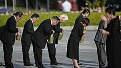 Os convidados oferecem água durante uma cerimónia comemorativa do 80.º aniversário do bombardeamento no Parque Memorial da Paz de Hiroshima, em Hiroshima, no oeste do Japão, quarta-feira, 6 de agosto de 2025. 