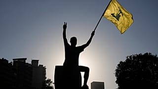 DOSSIER : Un partisan du Hezbollah brandit un drapeau du Hezbollah à Beyrouth, au Liban, le samedi 26 juillet 2025.