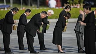 Guests offer water during a ceremony to mark the 80th anniversary of the bombing at the Hiroshima Peace Memorial Park in Hiroshima, western Japan, Wednesday, Aug. 6, 2025.