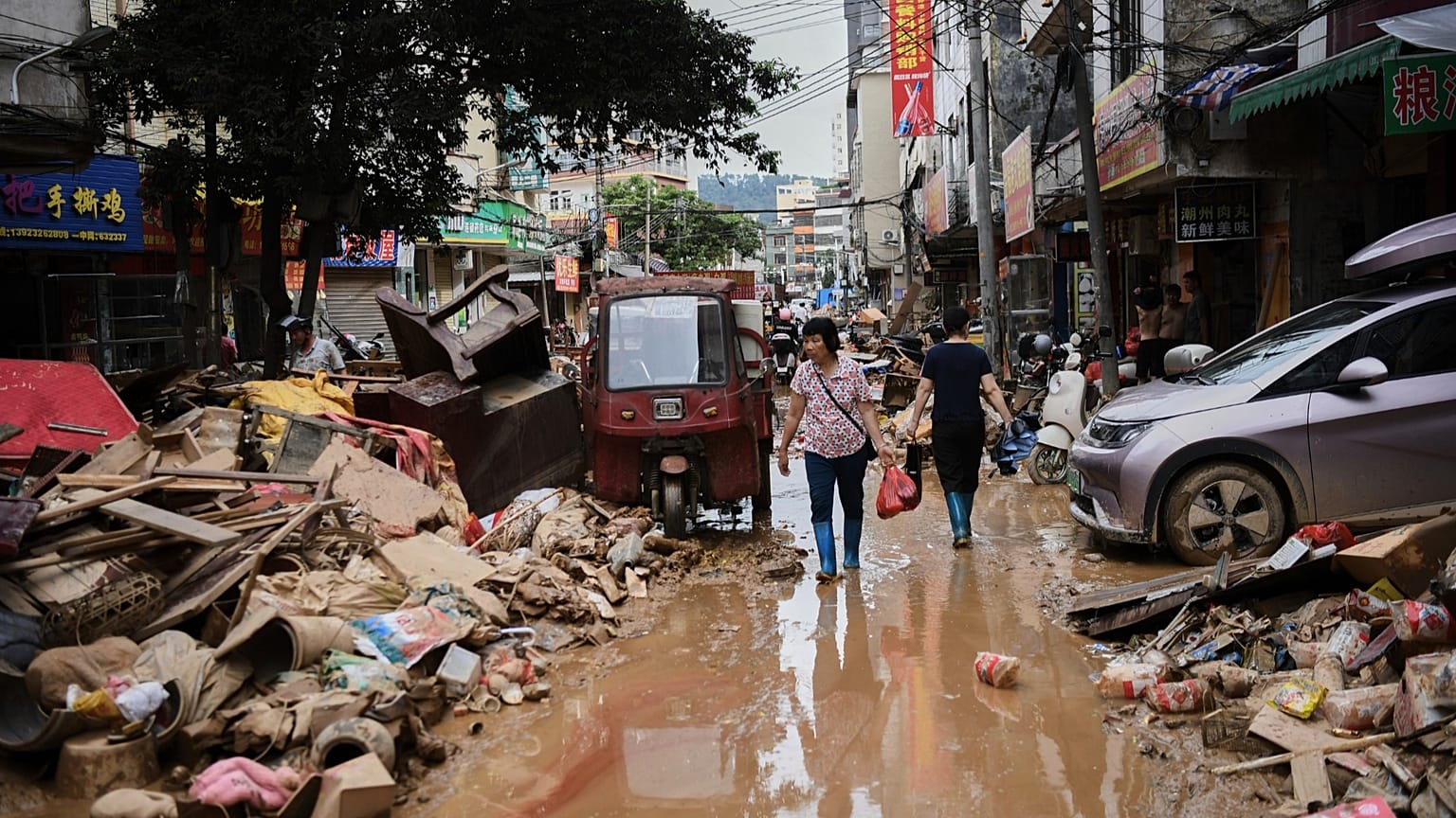 Xinhua Haber Ajansı tarafından yayınlanan bu fotoğrafta, bölge sakinleri 19 Haziran 2025 tarihinde Çin'in güneyindeki Guangdong Eyaleti'nin Huaiji İlçesi'nde selin vurduğu bir caddede enkazların arasından geçiyor.