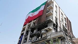 DOSSIER : Un drapeau iranien est accroché à un bâtiment qui a été touché par une frappe israélienne la semaine dernière, à Téhéran, Iran, mercredi 25 juin 2025.